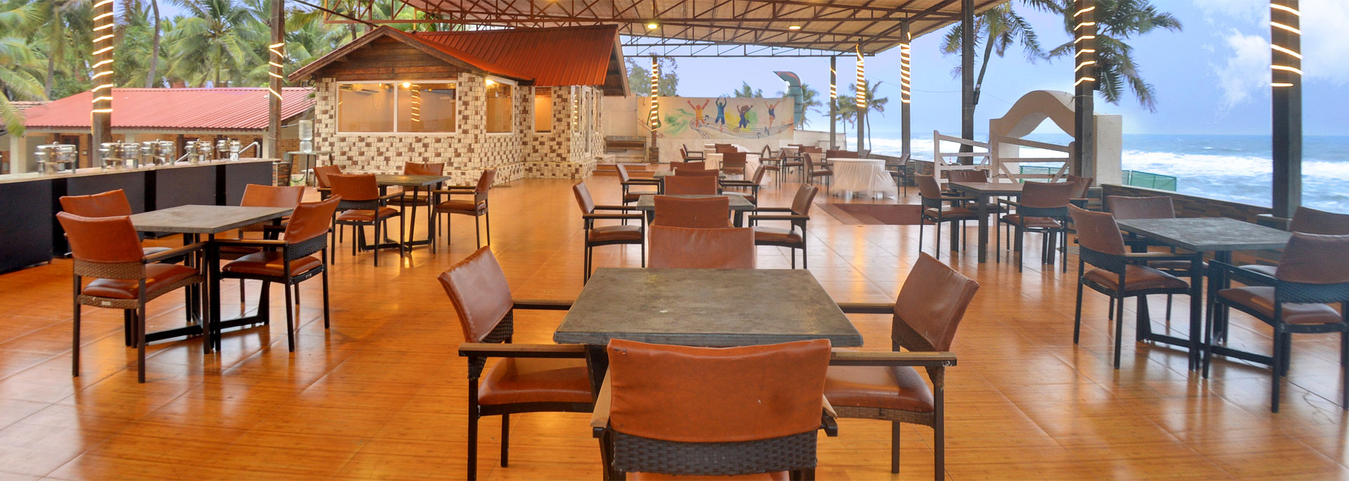 Cabin of beach restaurant with seating arrangements in Bluebay beach resort