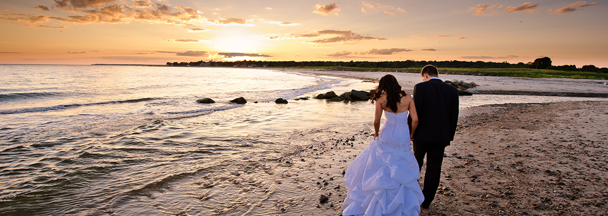 Newly married couple walking on the beach after their wedding held in the beach