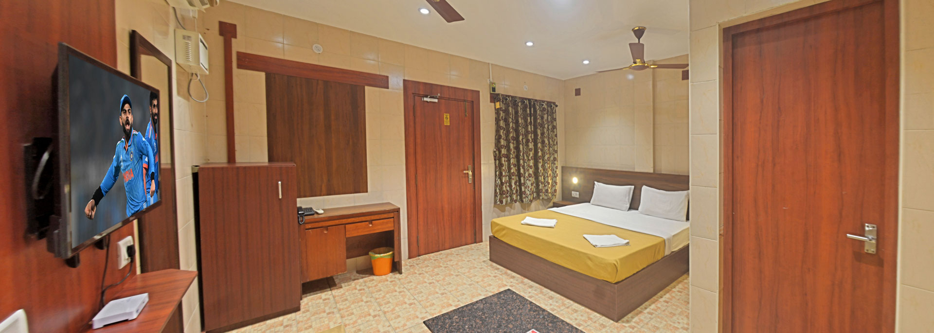 Spacious oceanside cottage room with a kingsize bed, television with set top box, Sofa and table, dressing table with mirror, fan and airconditioner in Bluebay beach resort, ECR, Chennai