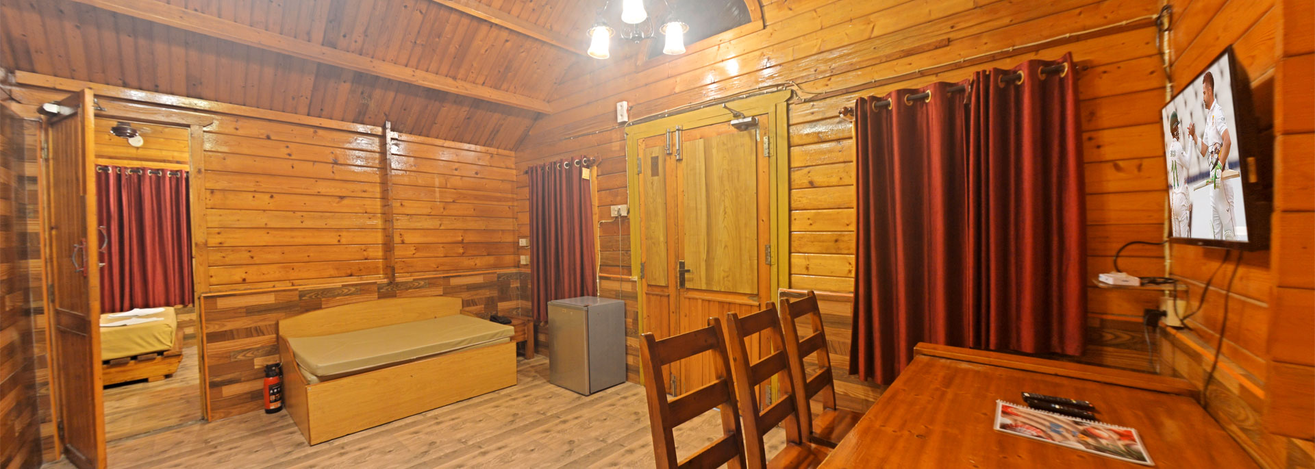 Wooden cottage with beds, table, adjoining room with dining arrangement in Bluebay Beach Resort, ECR, Chennai