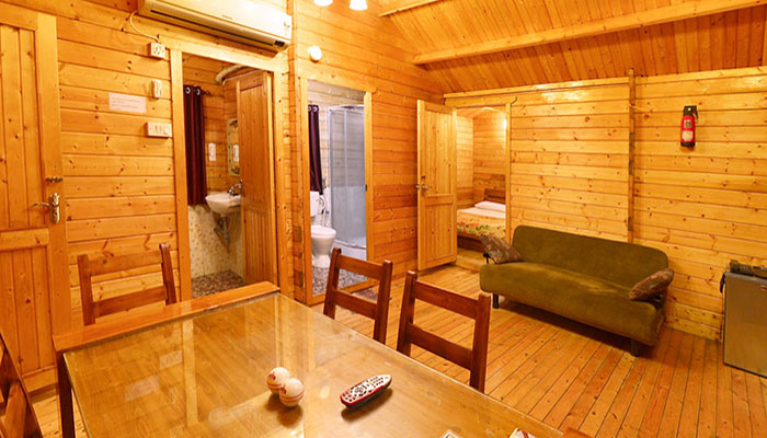 Wooden cottage with bedroom, dining table, soa, bathrooms, airconditioner, fire extinguisher in Bluebay beach resort